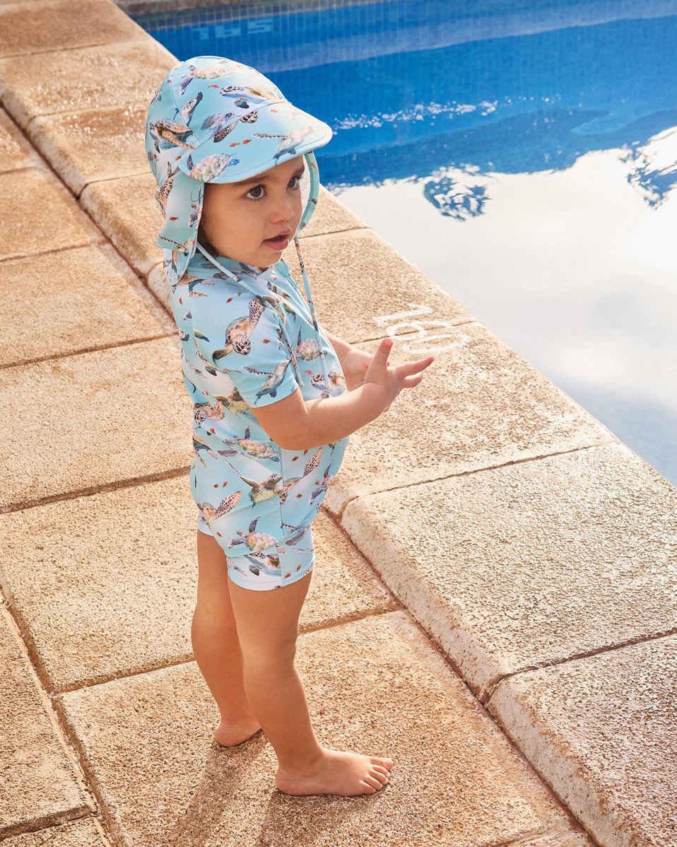 Nando - Baby Turtles - Elastisk ljusblå solhatt för barn i återvunnen polyester med UV-skydd 50+.