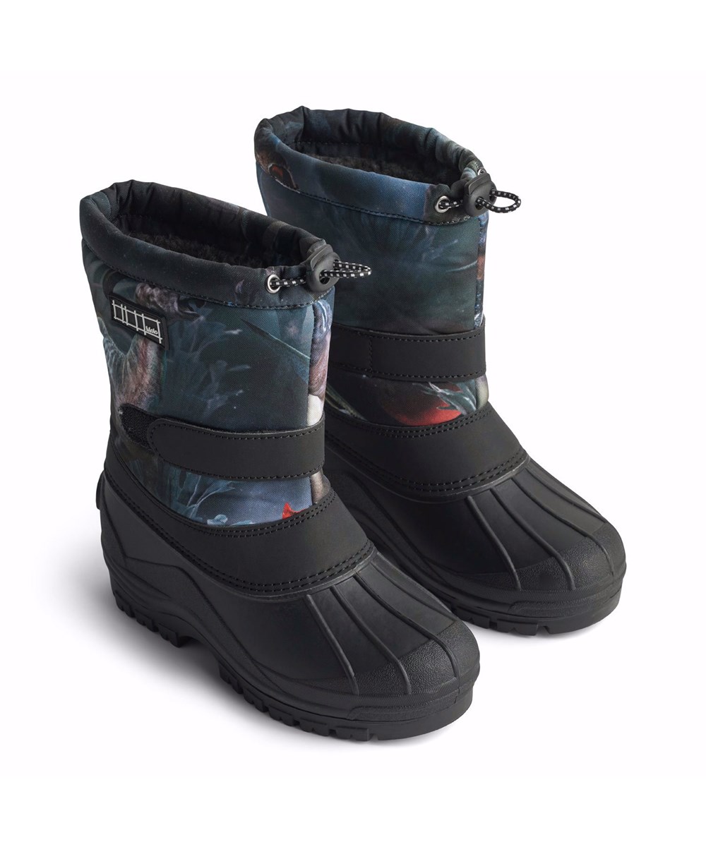 Driven - Dino In Space - Praktiska vinterstövlar för barn med en stabil och halkfri svart sula och ett rymdtryck av dinosaurier i nyanser av blått, grönt och brunt.