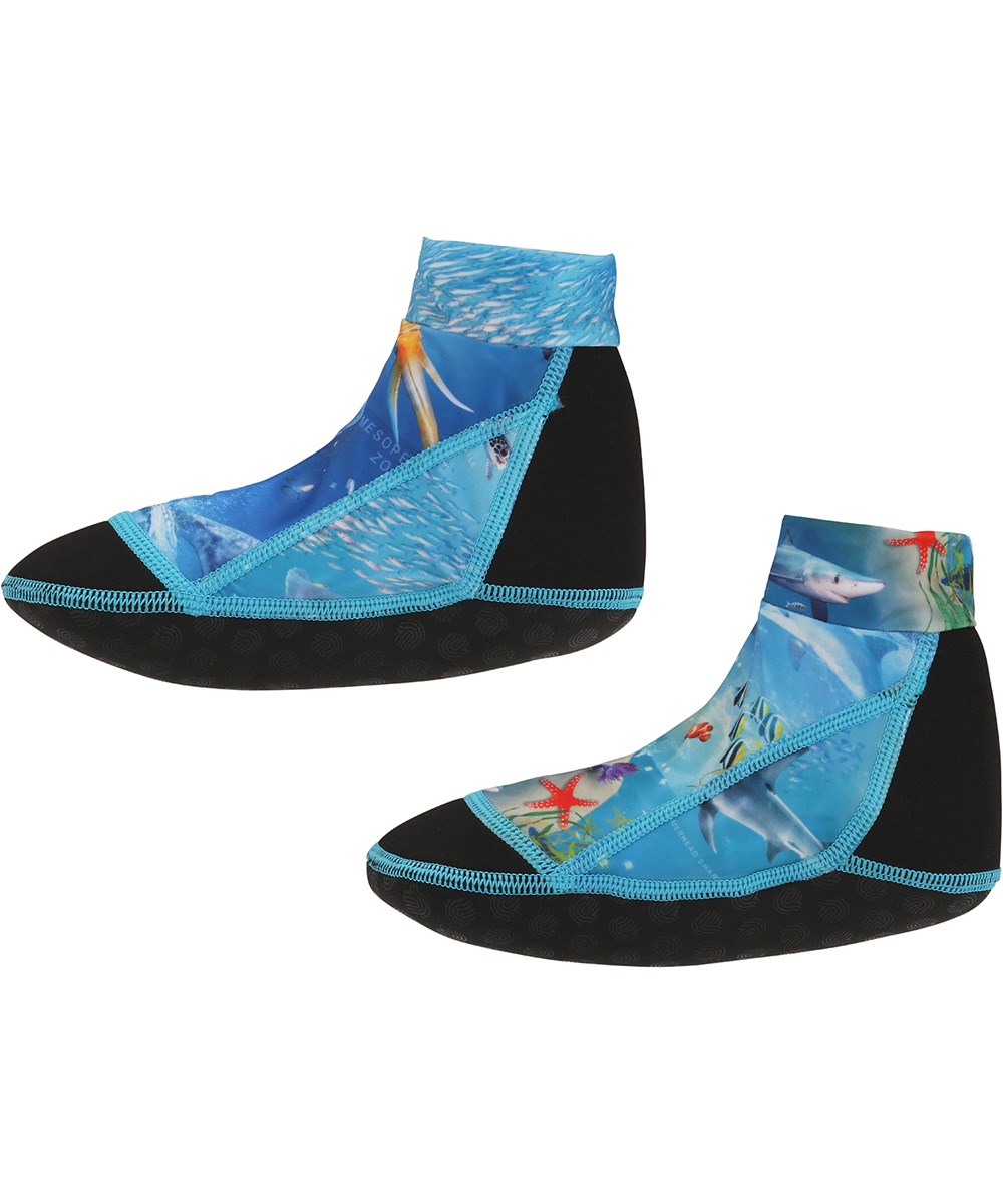 Zabi - Ocean Zones - Blå och svarta neopren badskor med havsmönster.