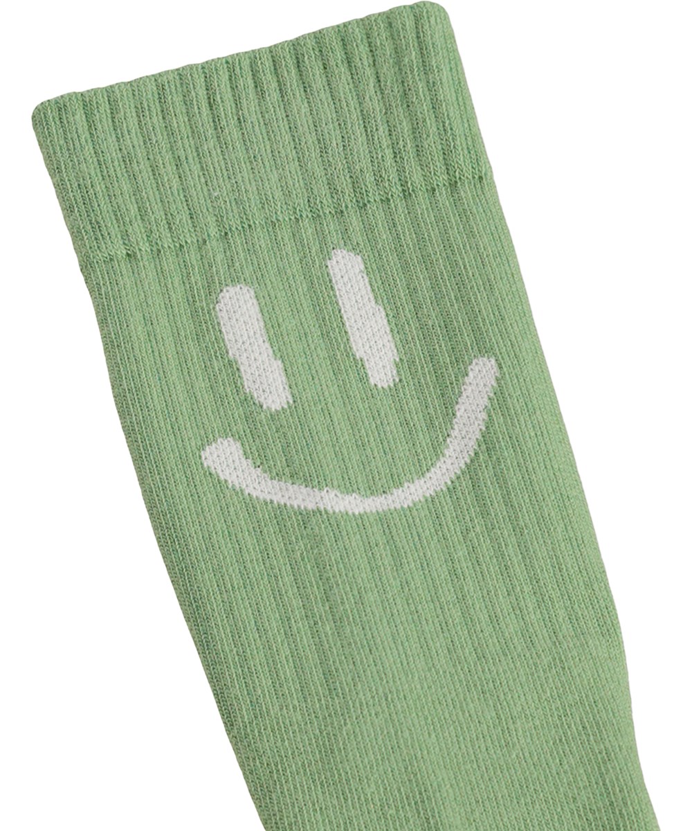 Norman - Sand Green - 2-pack strumpor för barn i grön och krämfärgad bomull med leendemotiv