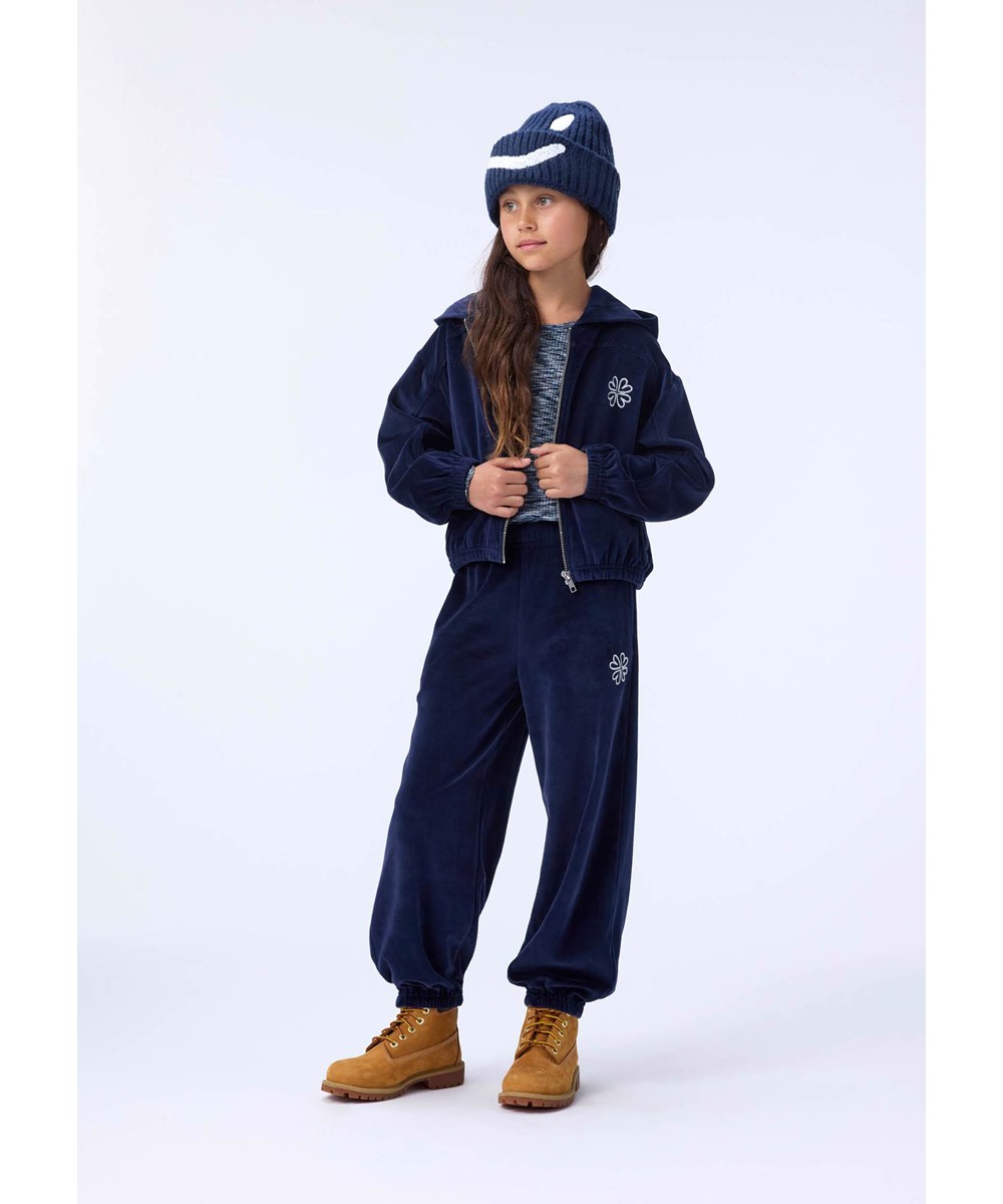 Kim - Night Navy - Donkerblauwe gebreide kindermuts in rib met omslag en geborduurde glimlach in het wit.