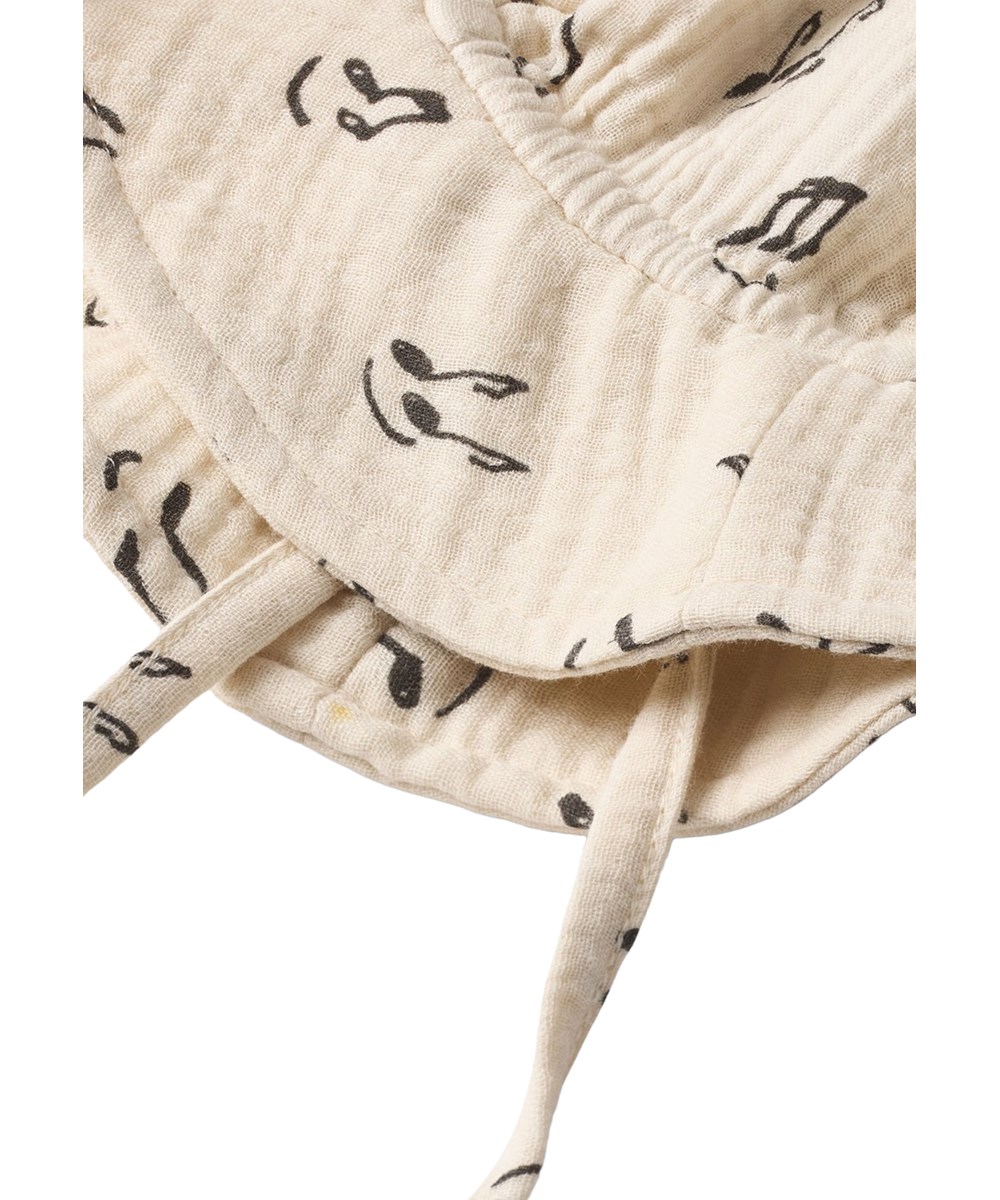 Noel - Happy Notes - Cream-coloured sun hat for the little ones made of organic cotton muslin with a brim and music print
