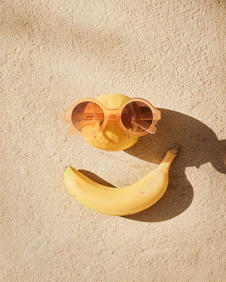 Shelby - Peach Fuzz - Round, orange sunglasses for children with UV protection.