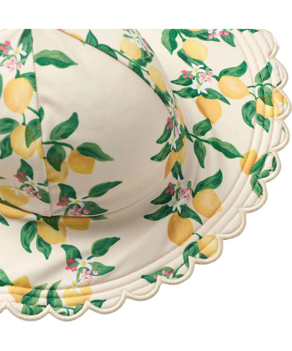 Nuka - Mini Citrus - Yellow stretchable sun hat with citrus print for children made from recycled polyester with UV protection 50+.