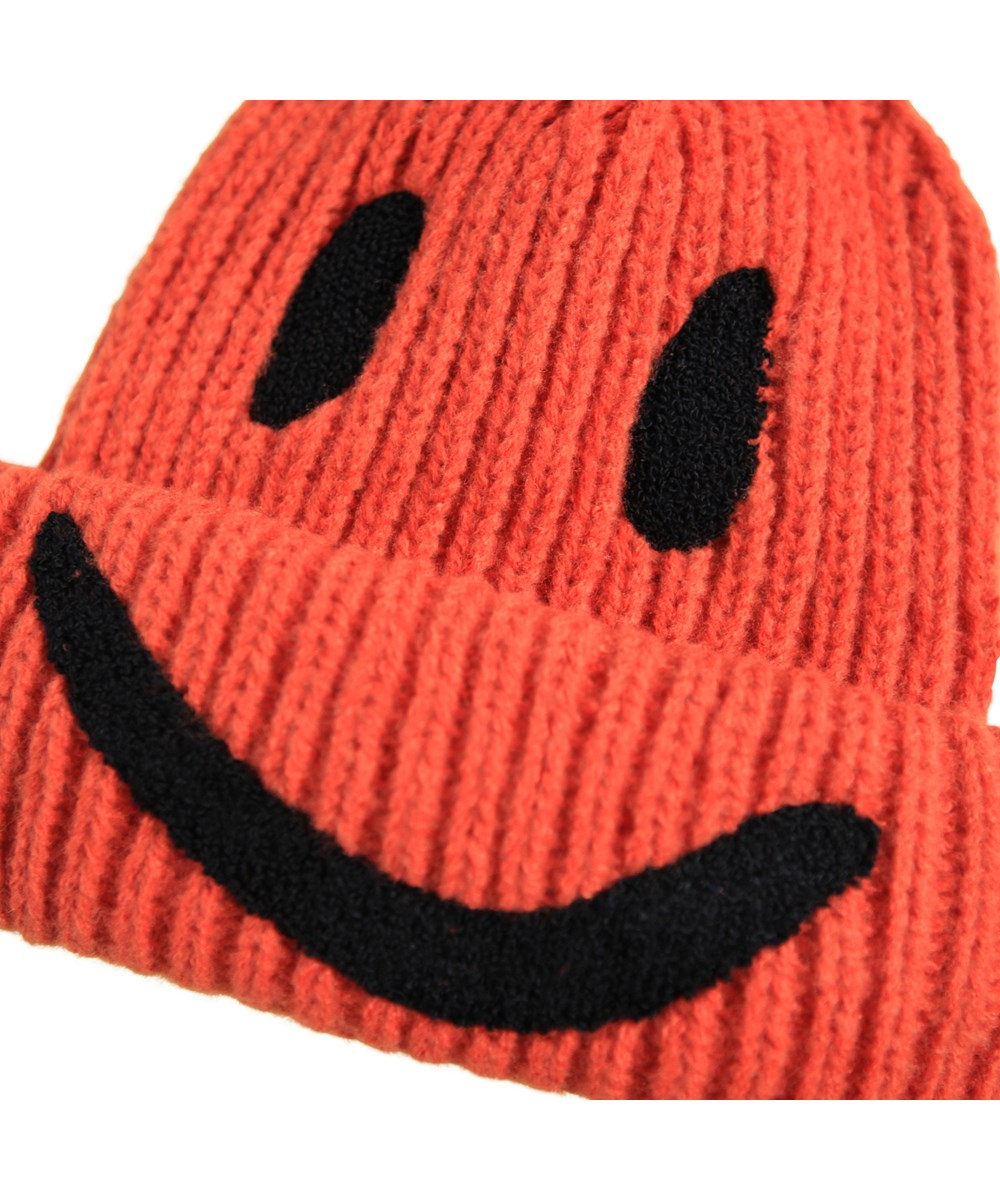 Kim - Rising Sun - Red rib-knitted beanie for children with roll up and embroidered smile in black.