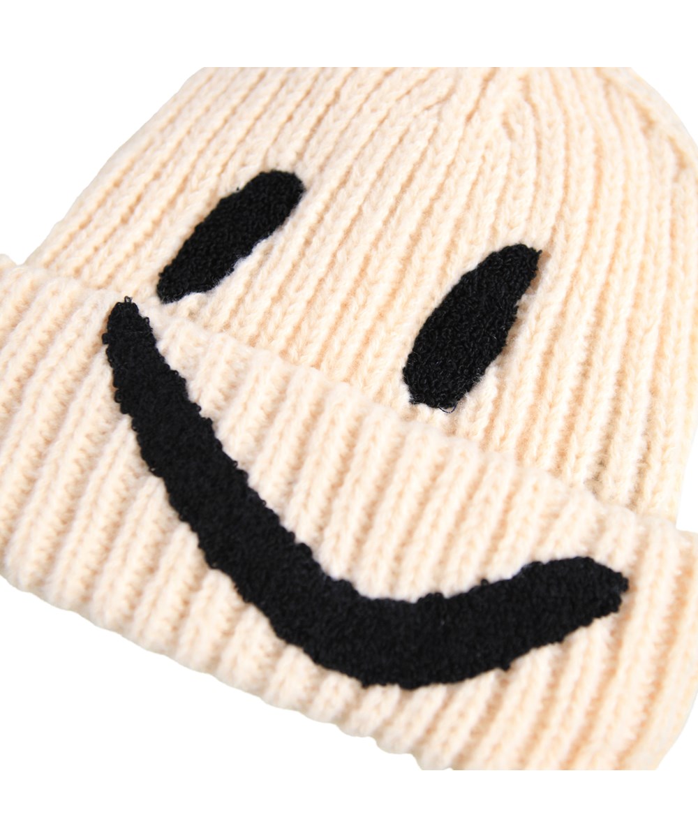 Kim - Vanilla - Cream-coloured rib-knitted beanie for children with roll up and embroidered smile in black.