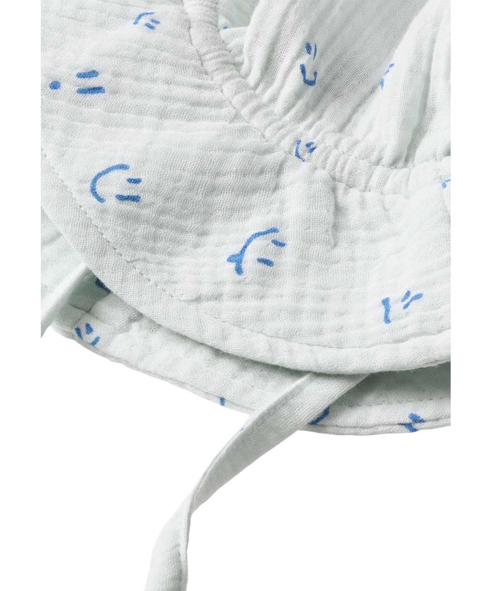 Noel - Blue Vibes - Lyseblå solhat til baby med skygge og happyprint i økologisk bomuldsmusselin