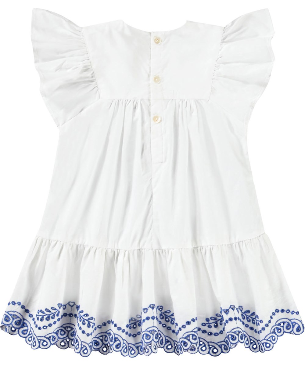 Cammas - Crisp White - Klänning för baby i ekologisk bomull med volangdetaljer och broderie anglaise. Klänningen är vit med blå detaljer.