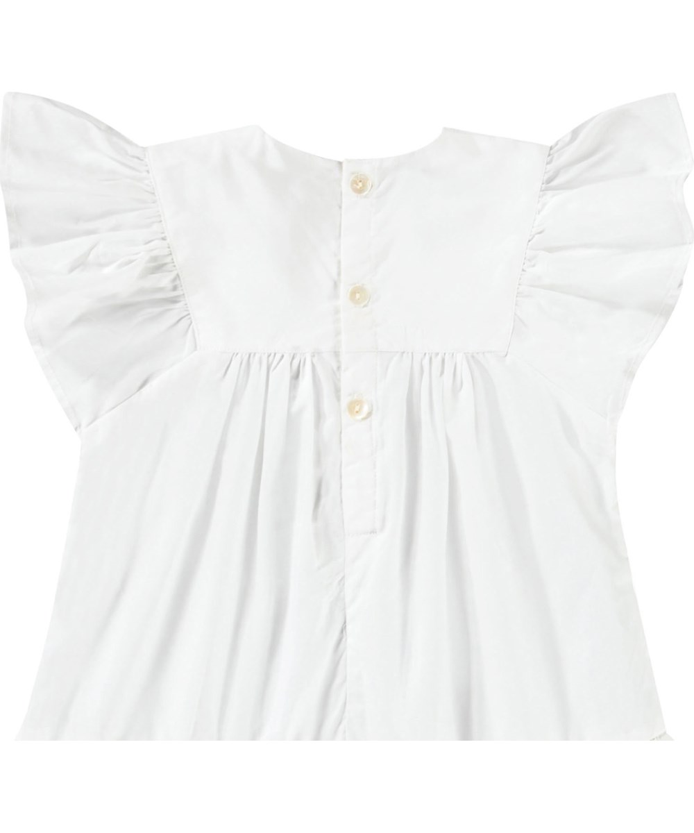 Cammas - Crisp White - Klänning för baby i ekologisk bomull med volangdetaljer och broderie anglaise. Klänningen är vit med blå detaljer.
