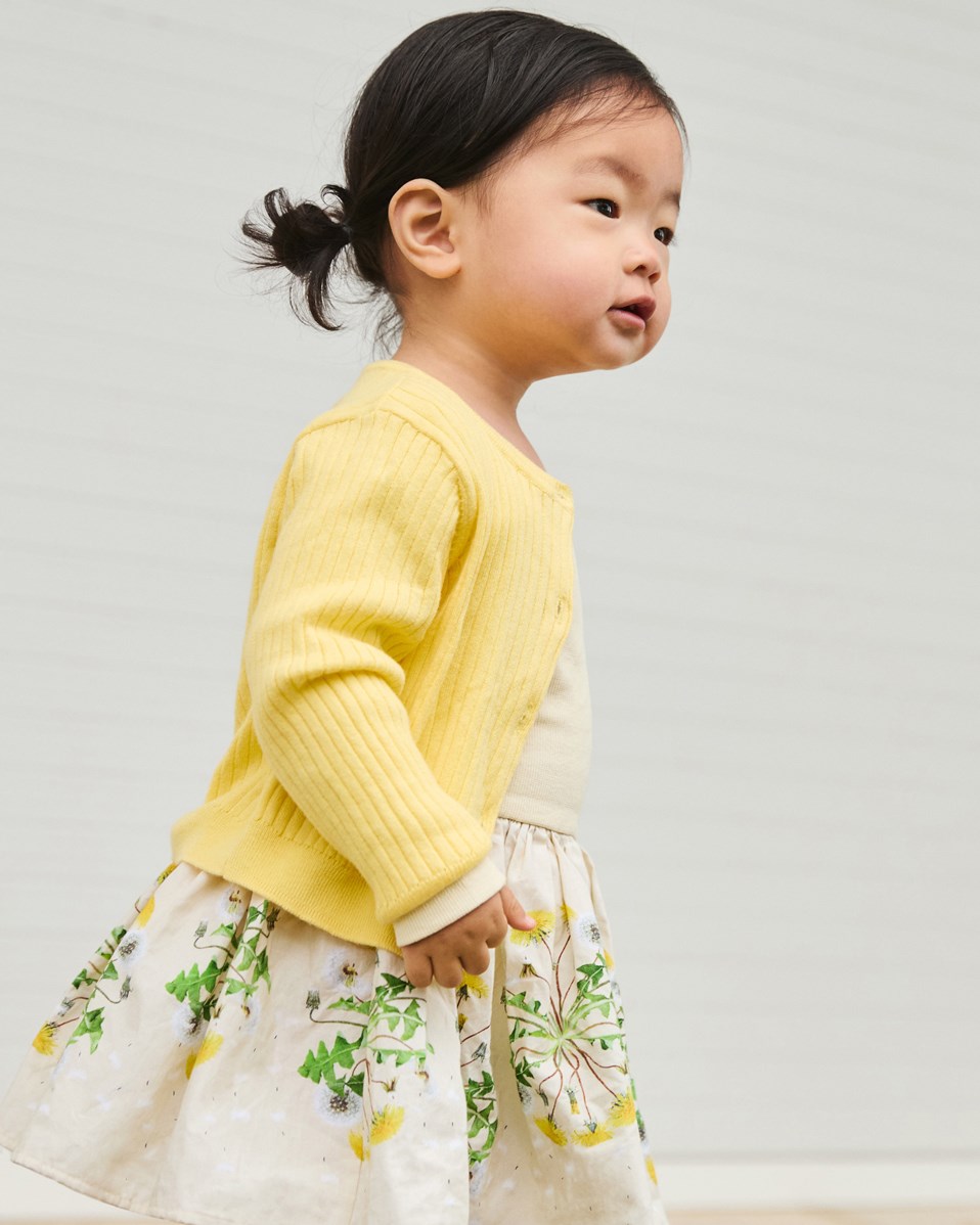 Candi - Baby Dandelion - Långärmad klänning för baby i ekologisk bomull. Klänningen är gul med maskrosmönster..