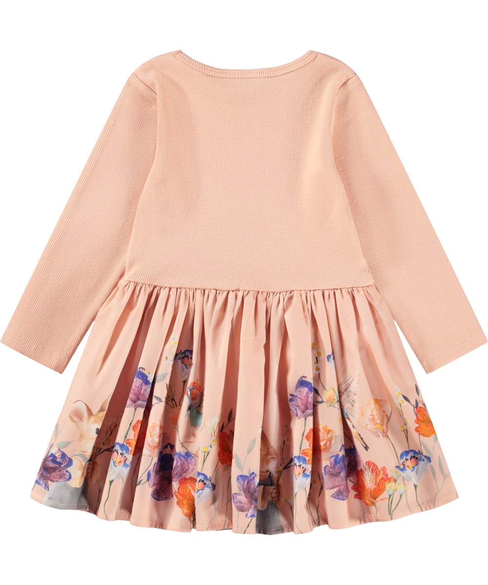 Candi - Rosey Bunny - Långärmad klänning för baby i ekologisk bomull. Klänningen är persikofärgad med djur klädda i kläder och blommor.
