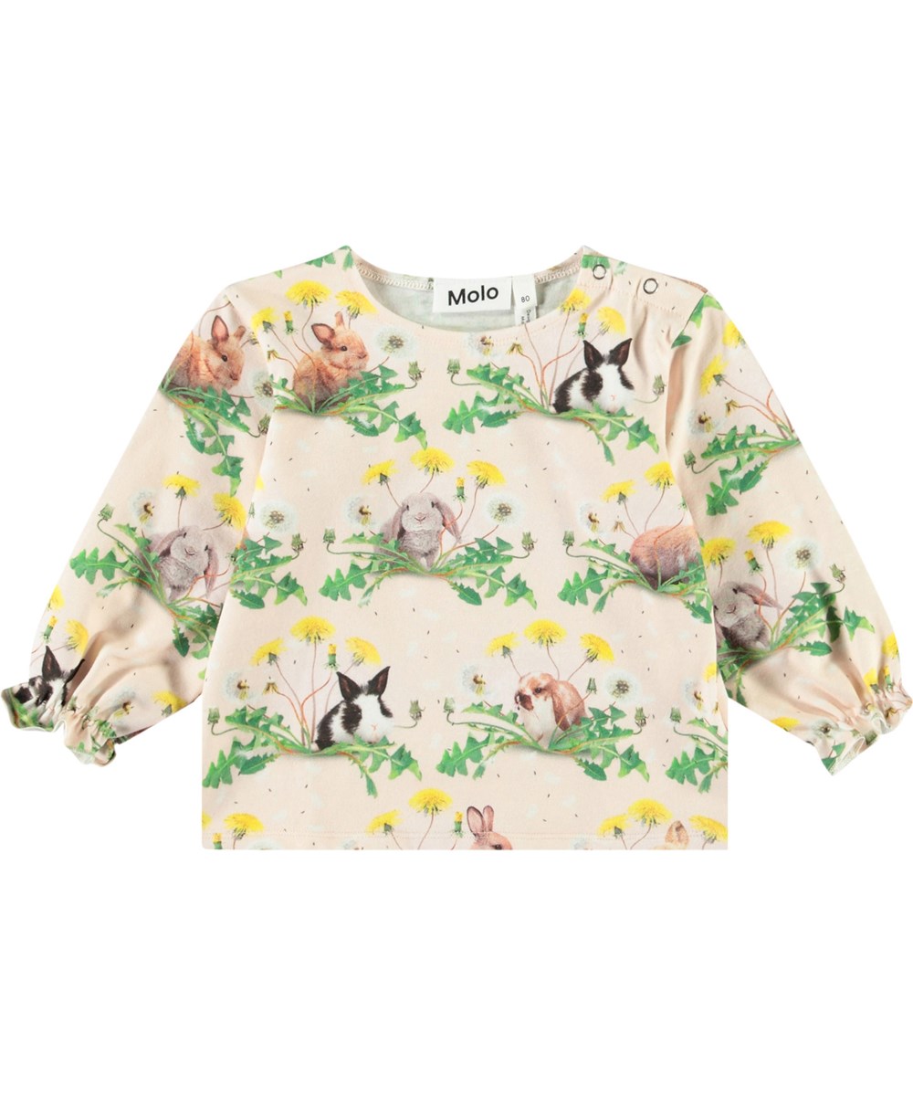 Elina - Bunnies United - Långärmad topp i ekologisk bomull för baby. Blusen är rosa med en tryck av kaniner och maskrosor.