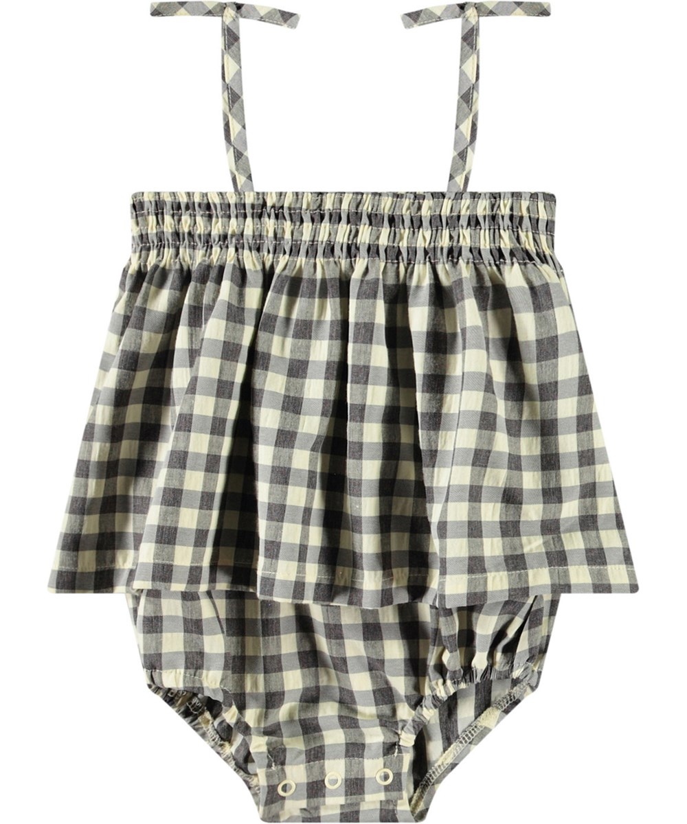 Flora - Sun Check - Checkered summer jumpsuit for baby in organic cotton. The jumpsuit has thin straps and no legs.