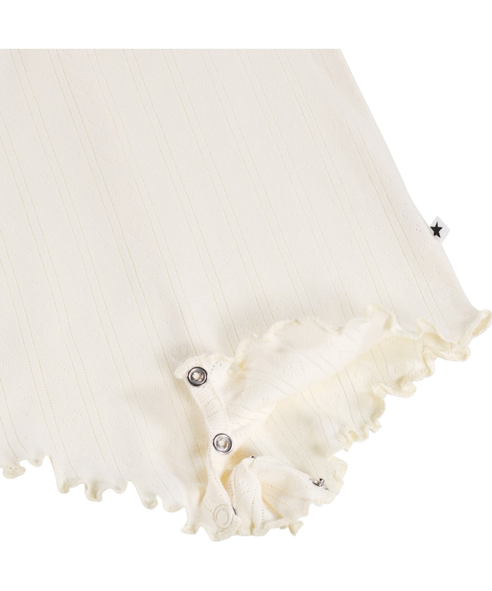 Florie - Pearled Ivory - White bodysuit for the little ones made of organic cotton pointelle with straps and ruffle details