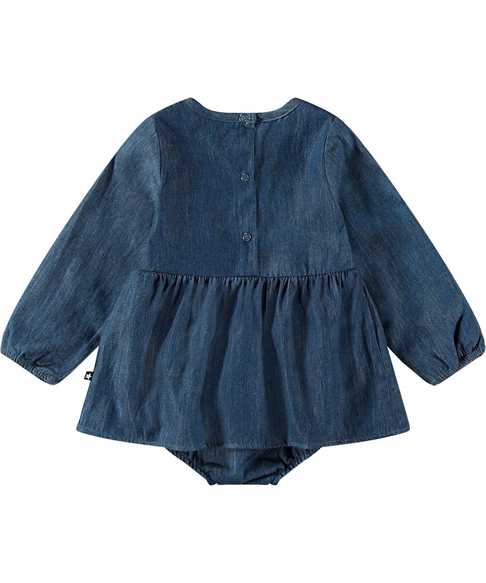 Francesca - Mid Blue Wash - Blue denim long-sleeved baby bodysuit made from organic cotton with smocked top and skirt.