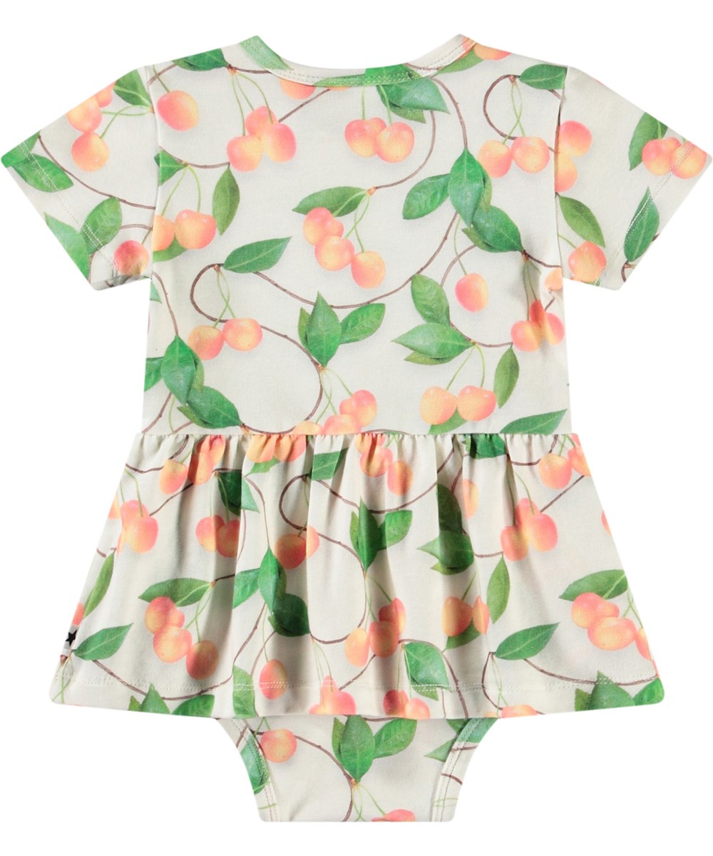 Frannie - Sweet Cherries - Baby's light coloured bodysuit in organic cotton. Short-sleeved with peplum skirt and cherry print.