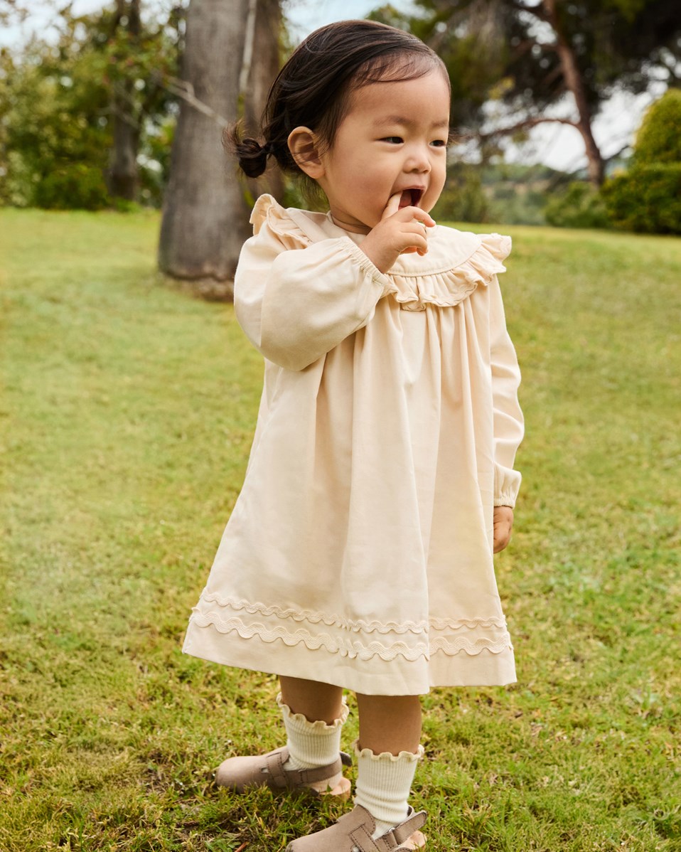 Cailin - Brazilian Sand - Beige baby dress in organic cotton with ruffle details.