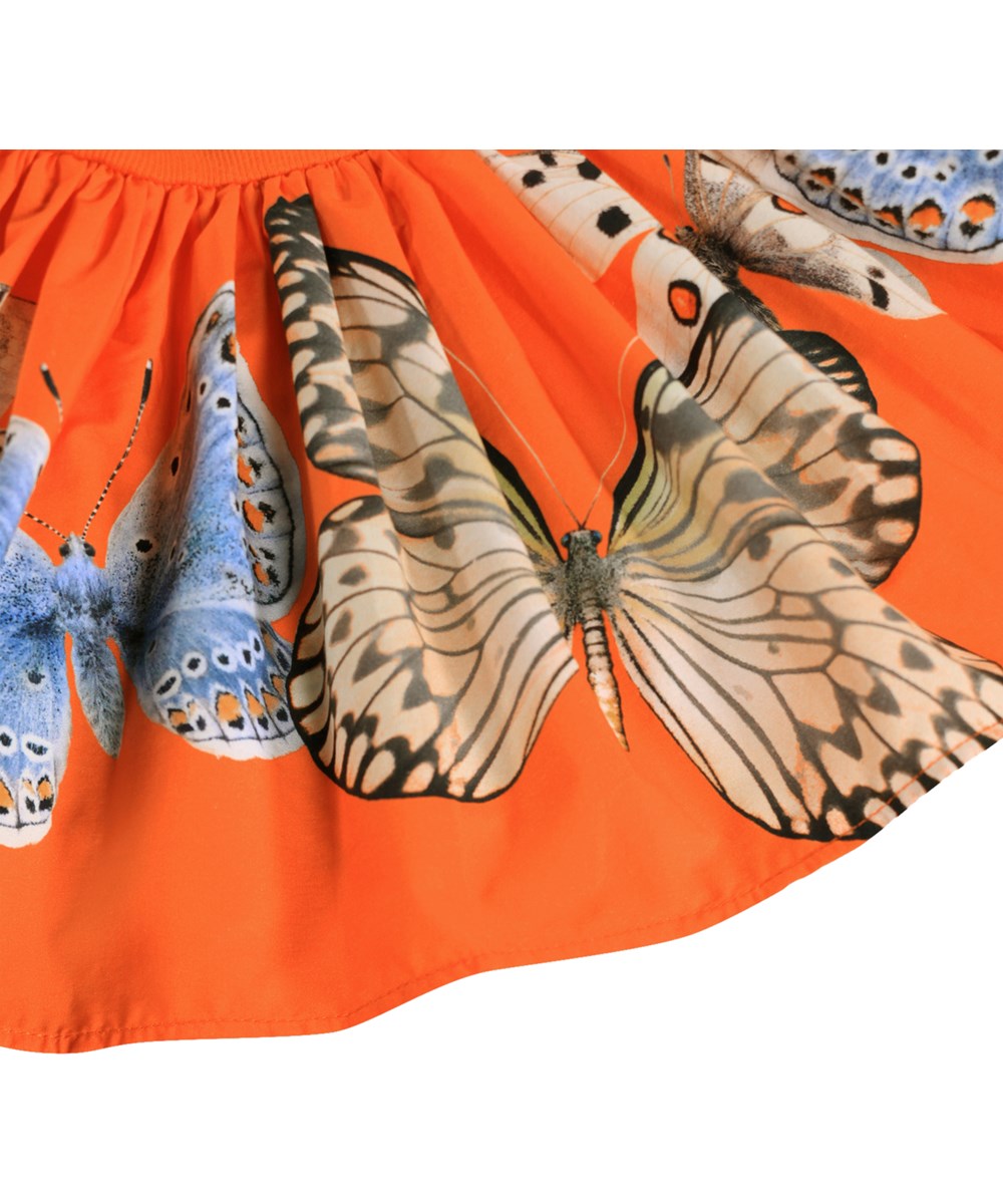 Caitlin - Fluttering - Orange dress for the little ones made of organic cotton with a butterfly print and puff sleeves