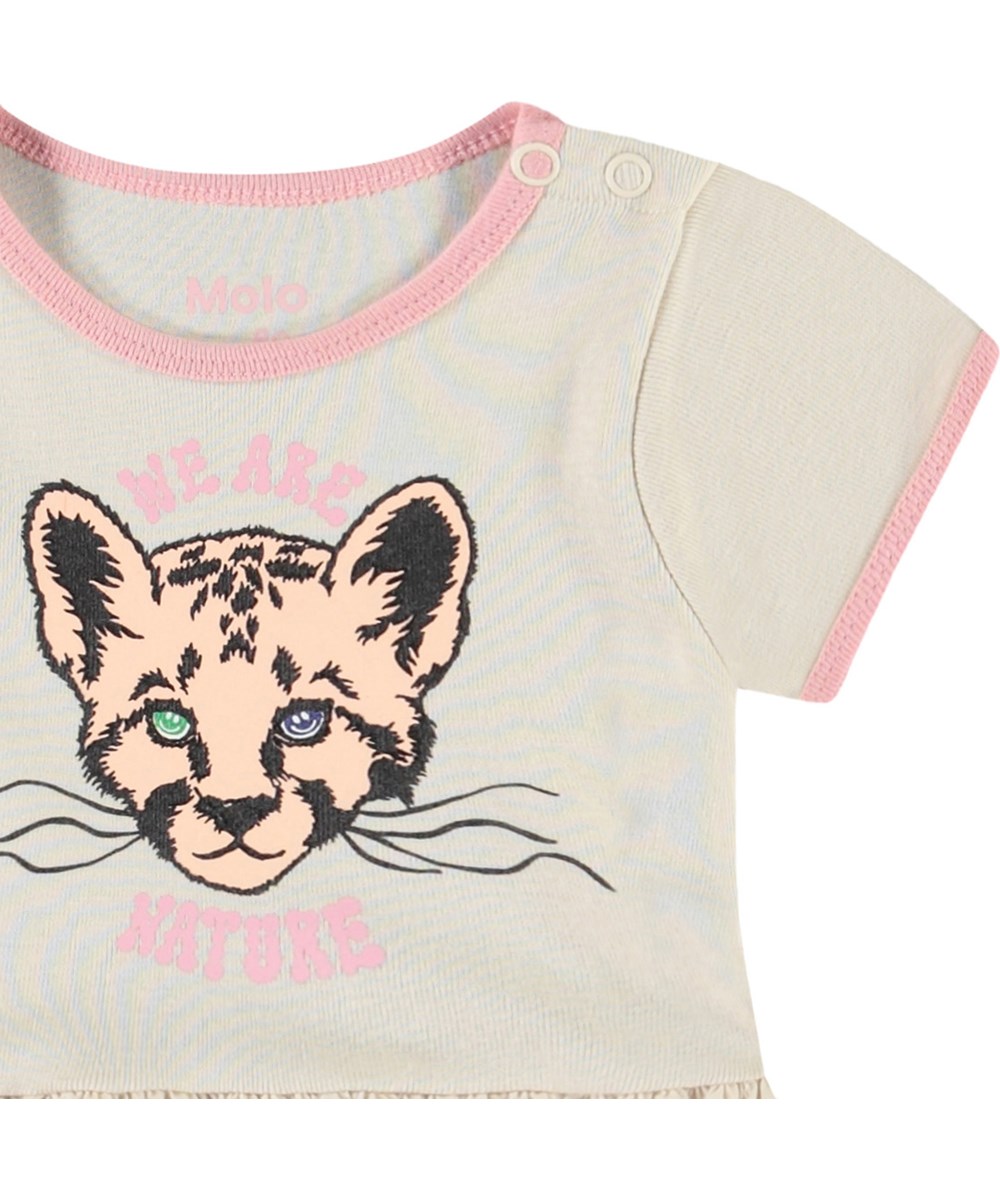 Carinelly - We Love Nature - Dress for baby in organic cotton. The dress is beige with light pink details and a print of baby animals.