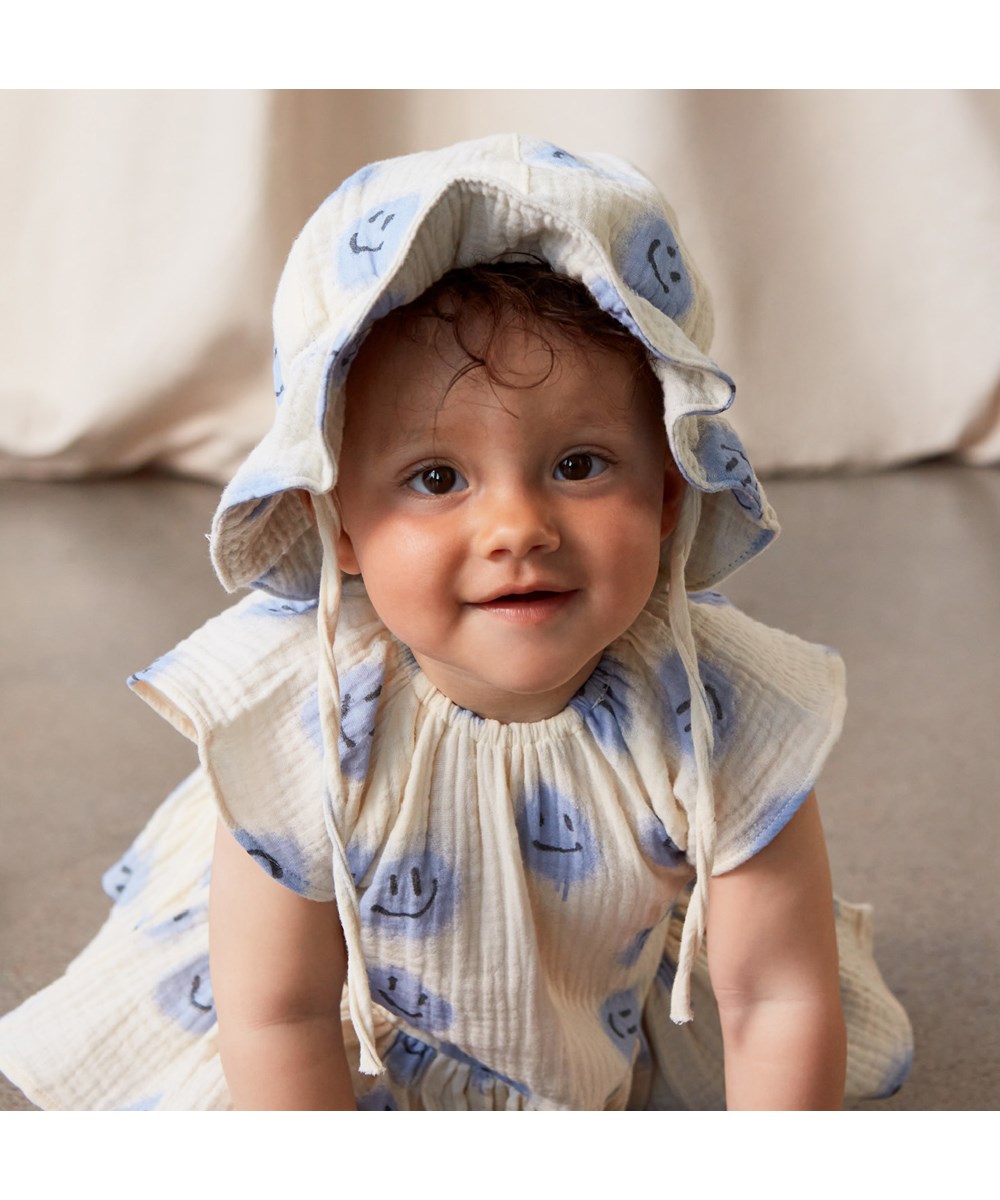 Carolina - Crisp Smiles - White baby dress with blue smiling faces