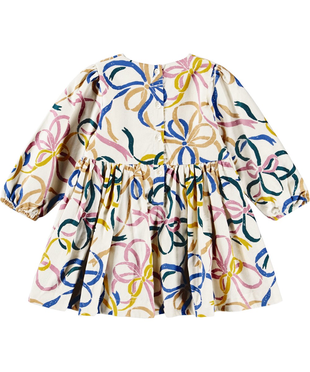 Chantelle - Festivity Bows - Off-white dress for the little ones  made of organic cotton velvet with a print of colorful ribbons.