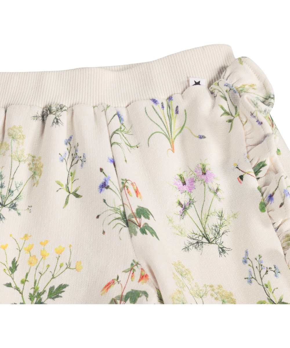 Sallie - Primavera - White trousers for the little ones made of organic cotton with a floral print and ruffles