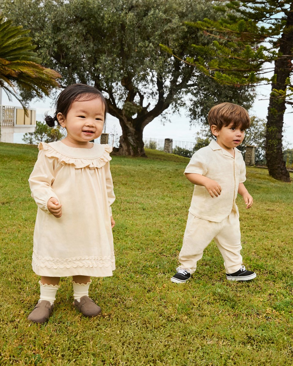 Cailin - Brazilian Sand - Beiges Babykleid aus Öko-Baumwolle mit Rüschen-Details.
