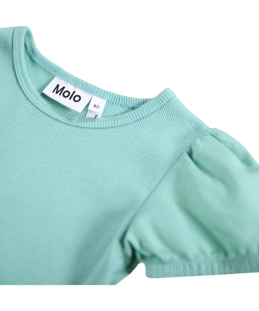 Caitlin - Wavy Moods - Grünes Popelinekleid für die Kleinen aus Öko-Baumwolle mit einem Druck von Gesichtern in verschiedenen Stimmungen.