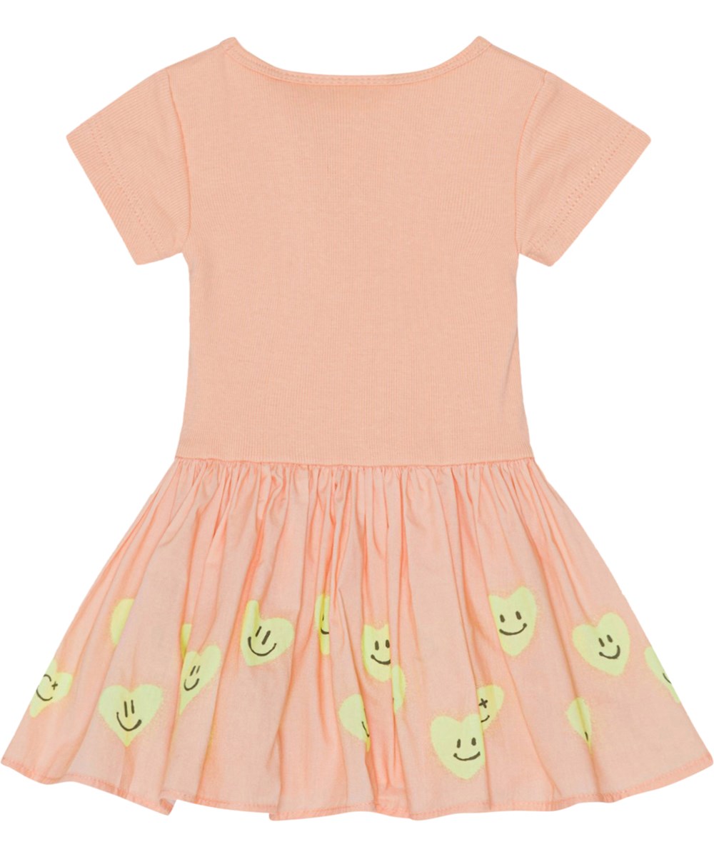 Carin - Line Of Hearts - Pfirsichfarbenes Öko-Babykleid mit Aufdruck auf dem Rock