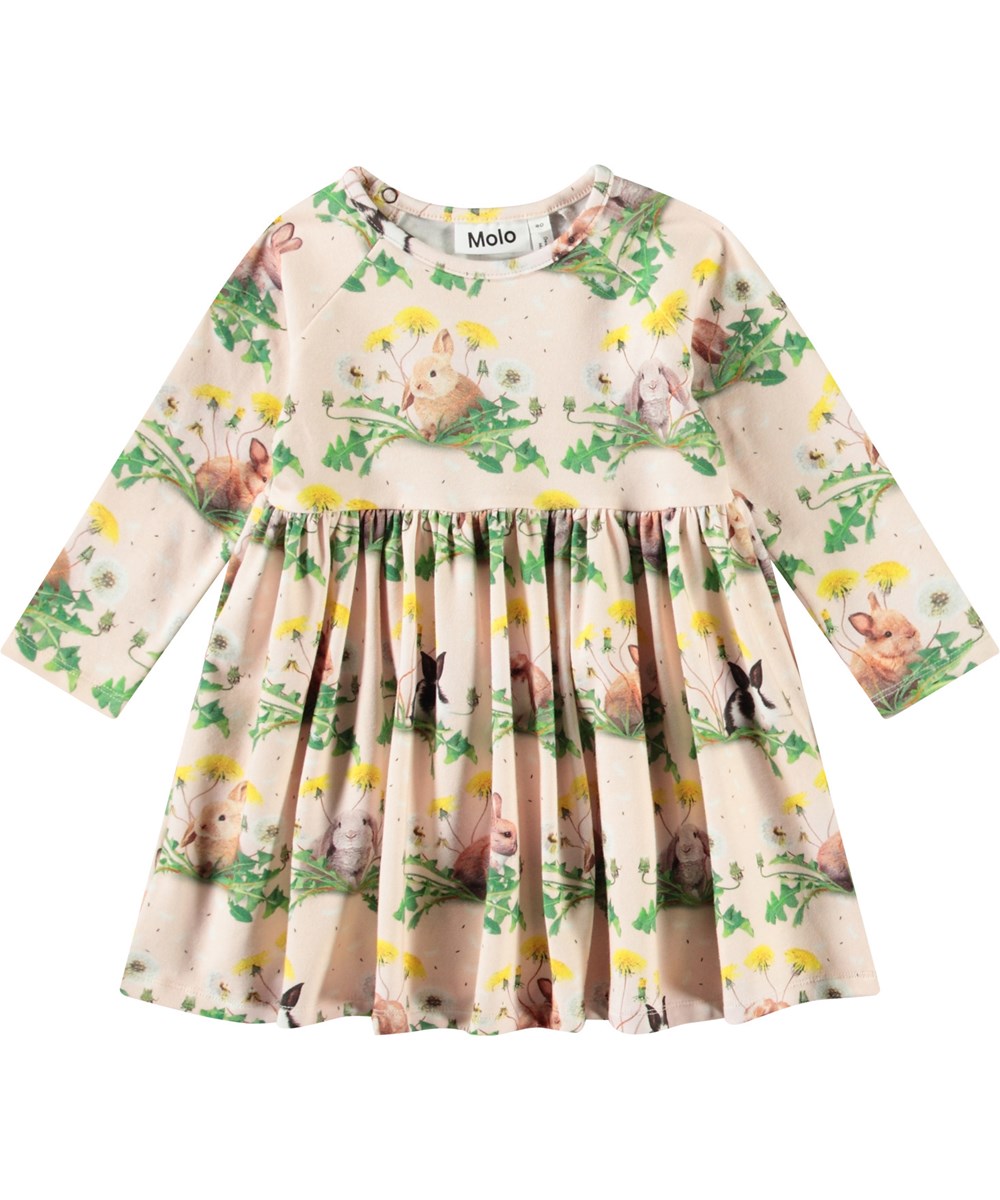 Charmaine - Bunnies United - Langärmeliges Kleid für Babys aus Öko-Baumwolle. Das Kleid hat einen Aufdruck von Hasen und Löwenzahn.