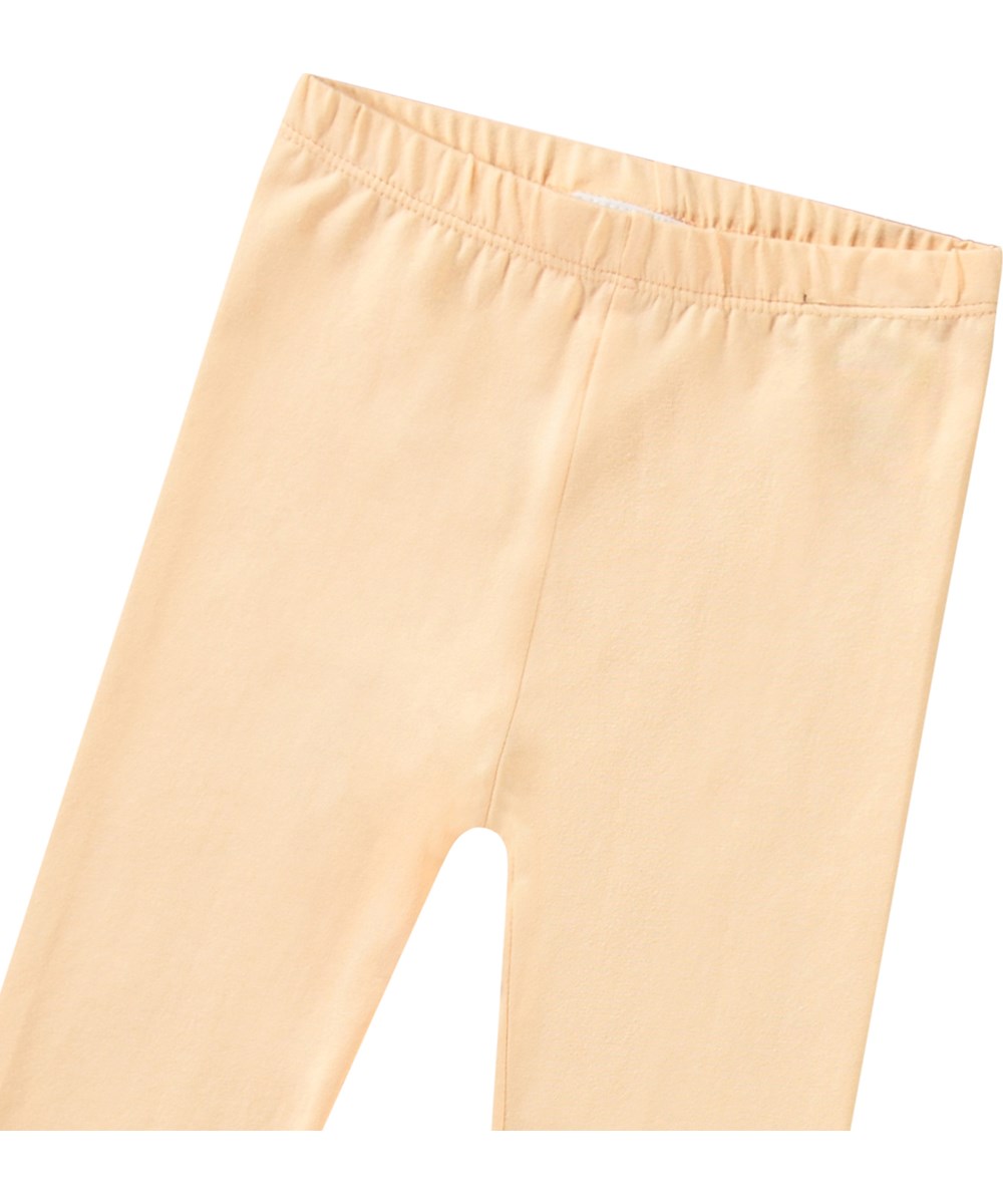Nette Solid - Pale Melon - Helle orangefarbene Baby-Leggings aus Öko-Baumwolle.