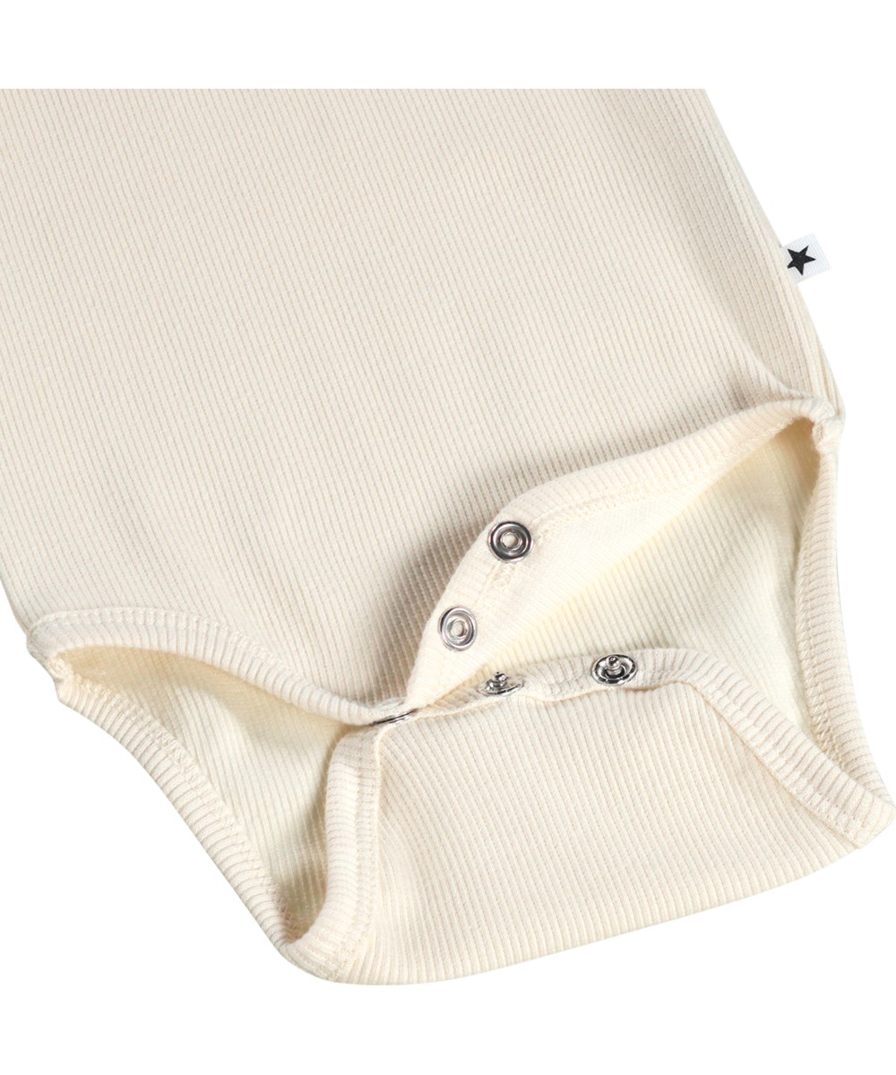 Faye - Summer Sand - Witte, lange mouwen romper voor de kleintjes gemaakt van biologisch katoenen rib met een rucheskraag.