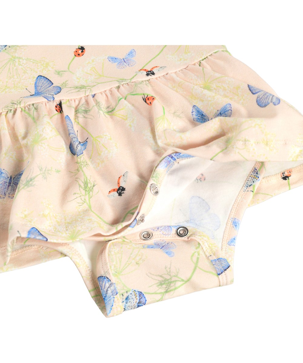 Frannie - Butterflys Cloud - Lichtroze, kort mouwloos jurkje voor de kleintjes gemaakt van biologisch katoen met aangehecht rompertje en vlinderprint.