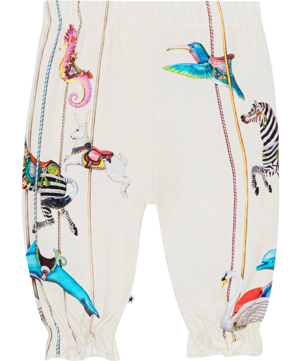 Selena - Carousel Pants - Voor kleine kinderen een gebroken witte jersey broek van biologisch gemêleerd katoen met een feestelijke print van kleurrijke draaimolendieren