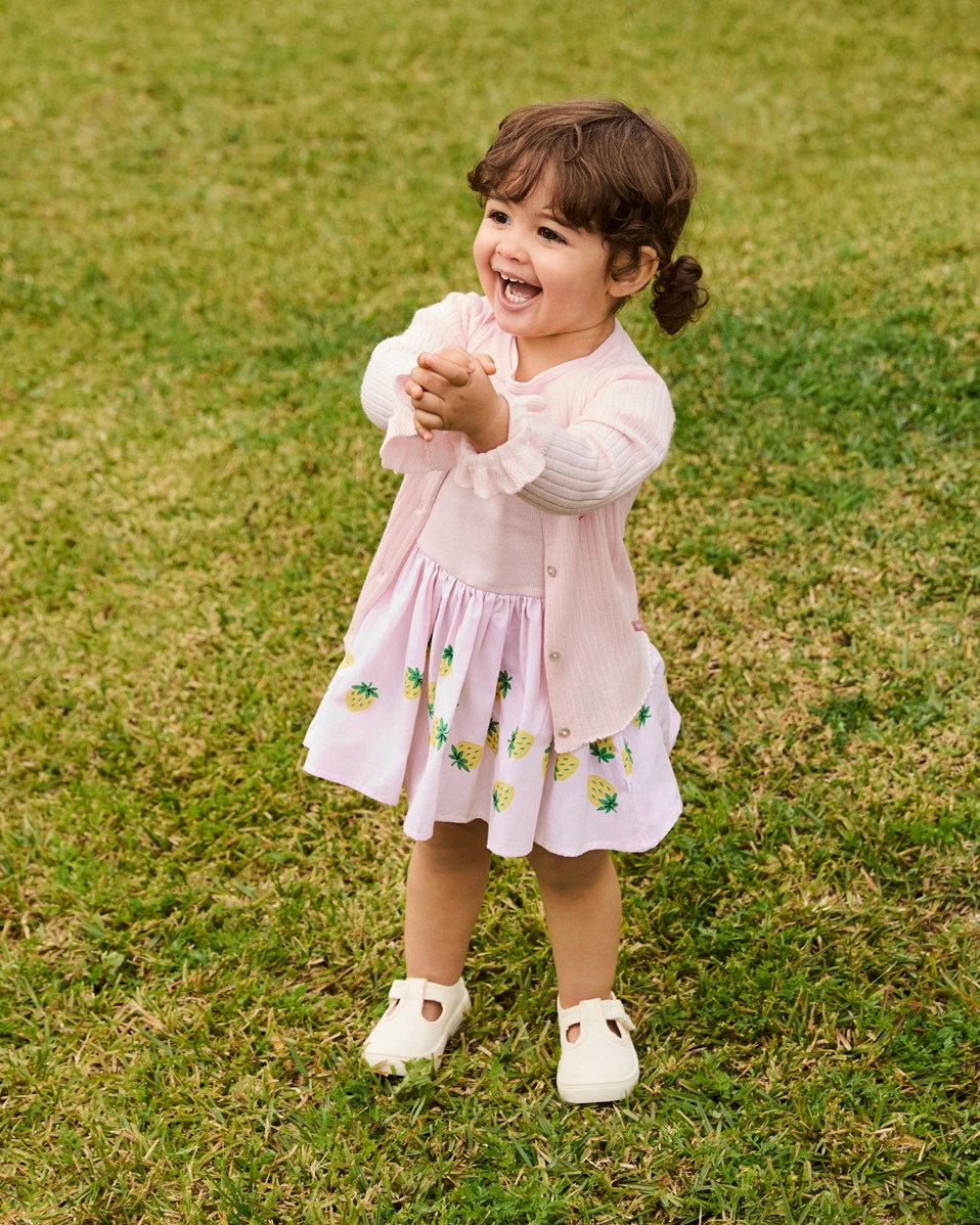 Carin - Bouncy Berries - Babyjurk van biologisch katoen. De jurk is roze en heeft een gele aardbeienprint.