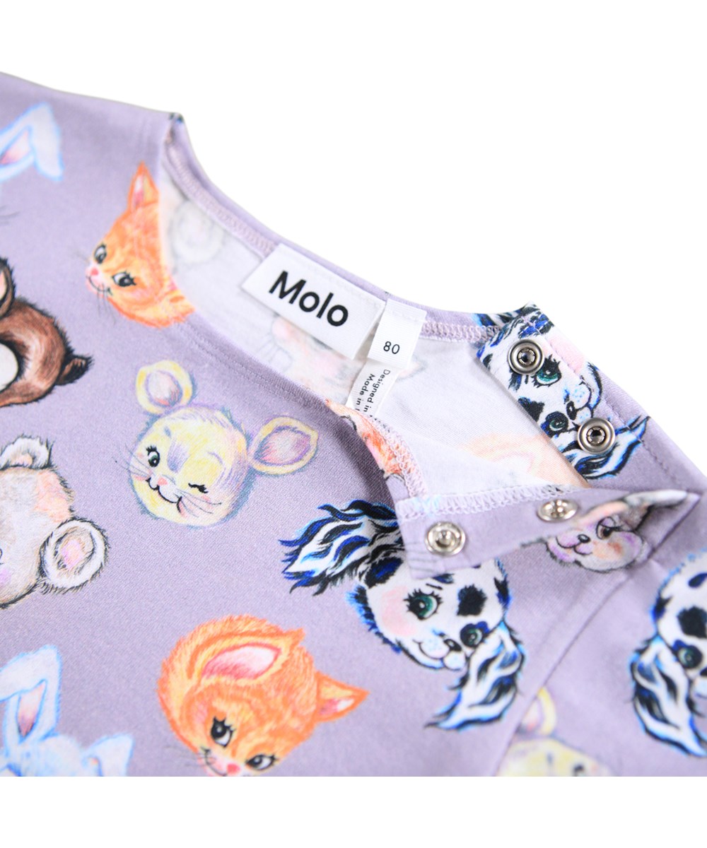 Elina - Itty Bitty - Lichtpaarse longsleeve voor de kleintjes gemaakt van biologisch katoenen jersey met een print van getekende dieren. De longsleeve heeft een ruimvallende pasvorm en mouwen met elastiek rond de mouwen wat zorgt voor een kleine ruche. Er zitten drukknopen op