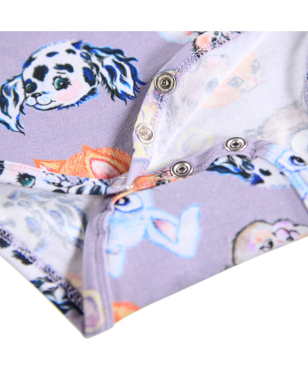 Foss - Itty Bitty - Cremefarvet langærmet body i ribbet økologisk bomuld til de mindste. Bodyen har en poplinkrave, knaplukning i ryggen og trykknapper mellem benene for nem påklædning.