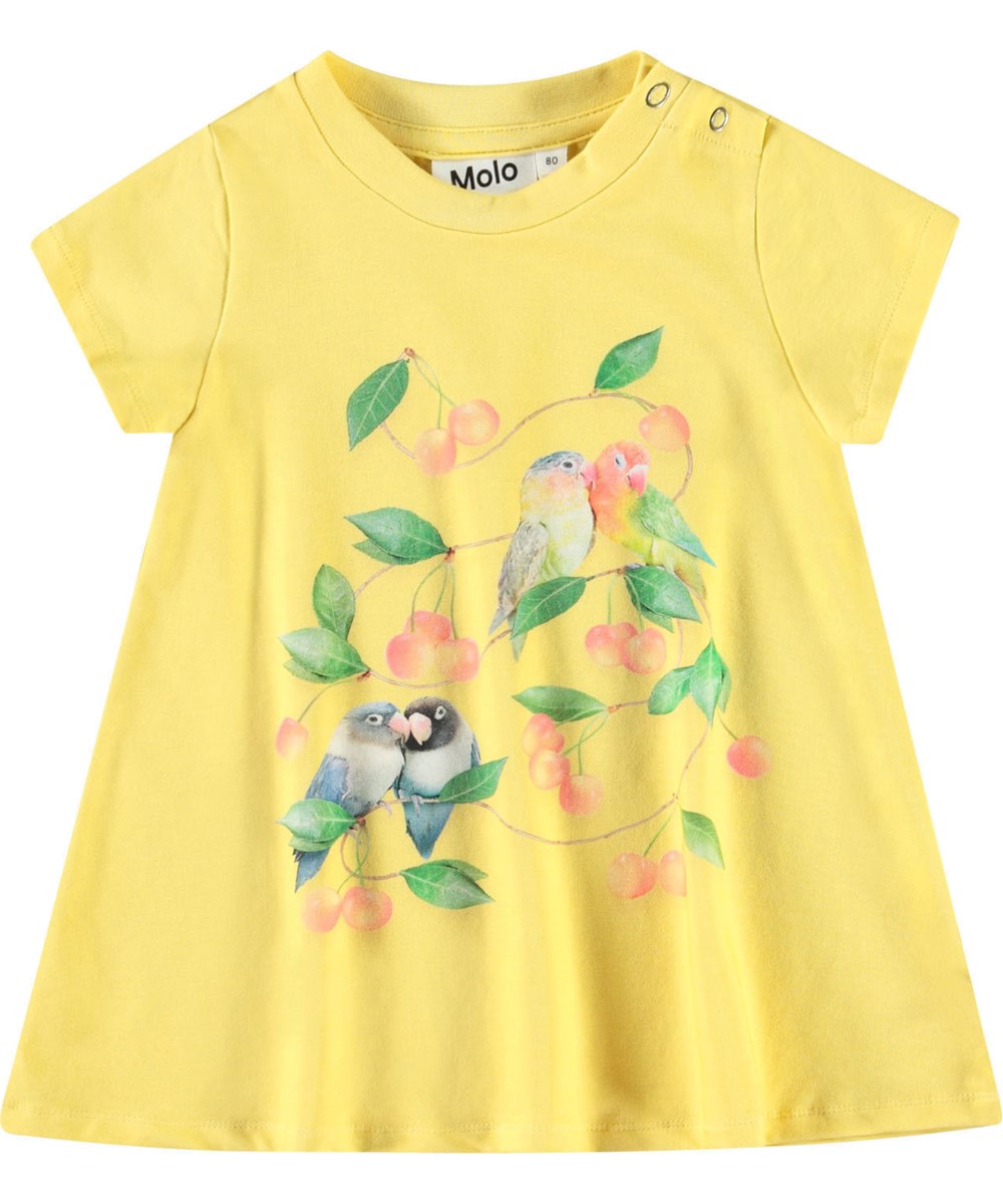 Cosimo - Love Birds Dress - A-formet kjole i økologisk bomuld til baby. Kjolen er gul med print af små papegøjer og kirsebær.