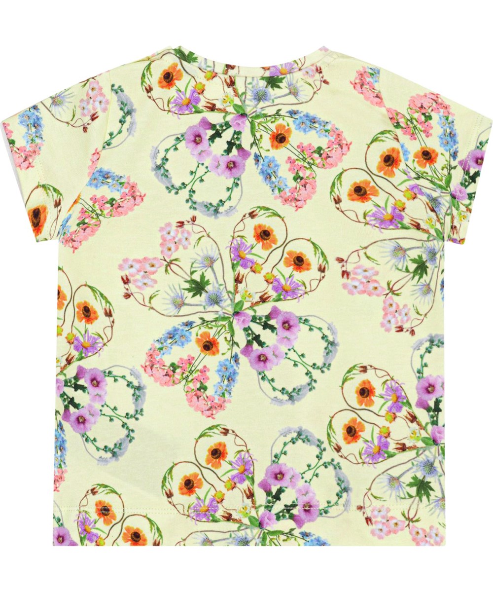 Elly - Flower Love - Gul t-shirt i blødt økologisk bomuld med et alloverprint af farverige blomster, som danner smukke silhuetter af kløvere