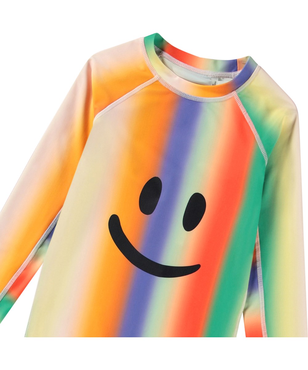 Neptune LS - Smile In Colours - Regenbogenfarbener Rashguard für aktive Kinder aus recyceltem Polyester mit UV-Schutz 50+.
