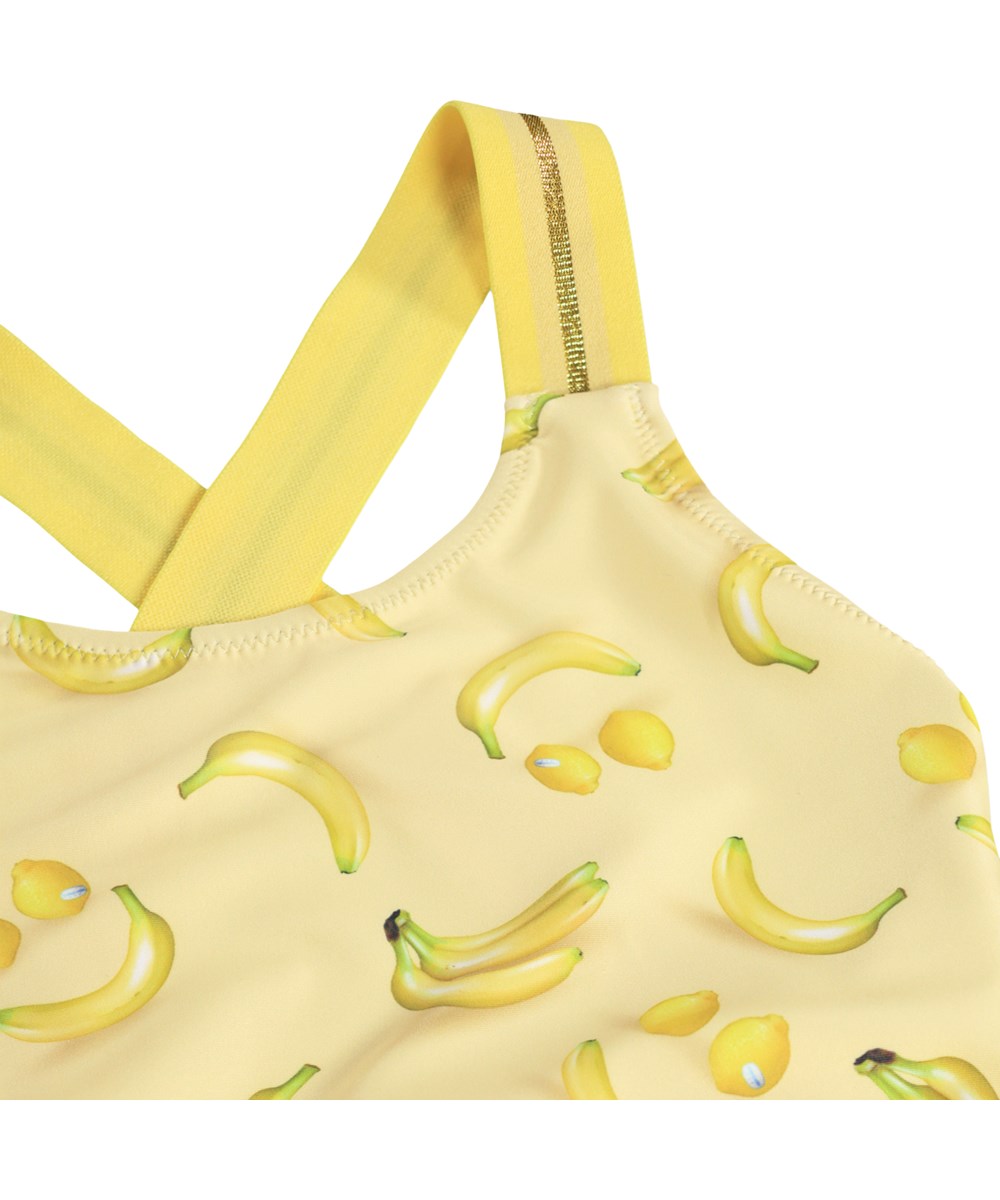 Neve - Lemon Banana - Gelber Badeanzug mit Bananenmuster für Kinder aus recyceltem Polyester und UV-Schutz 50+.