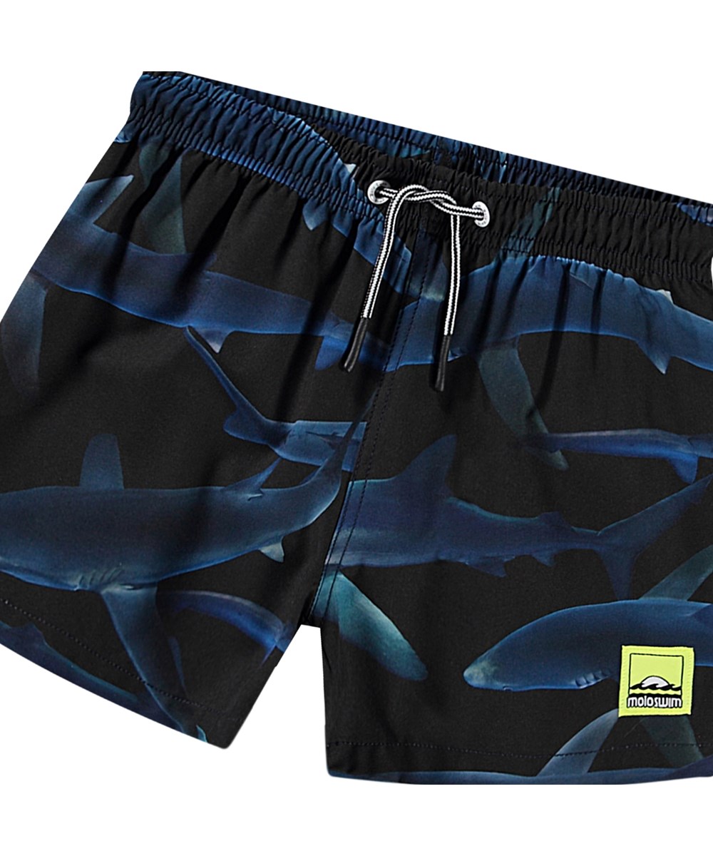 Niko - Midnight Sharks - Schwarze sportliche Badehosen für aktive Kinder aus recyceltem Polyester mit UV-Schutz 50+.