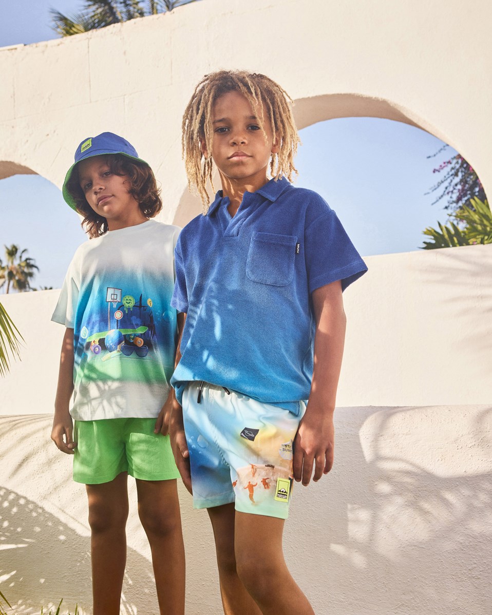 Niko - My Childhood - Hellblaue und hellgrüne sportliche Badehosen für aktive Kinder aus recyceltem Polyester mit UV-Schutz 50+.