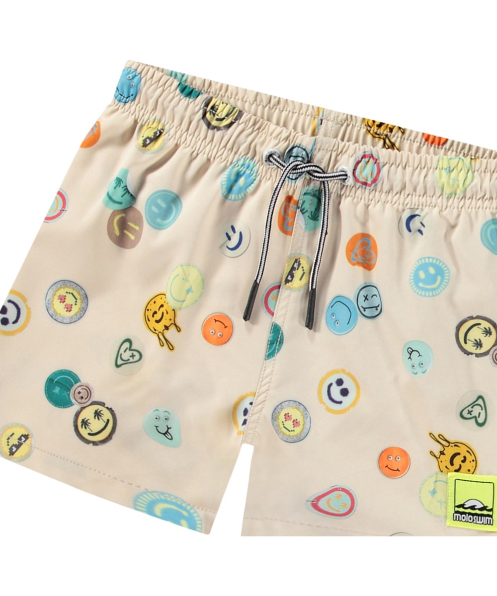 Niko - Sand Smile - Beige sportliche Badehosen für aktive Kinder aus recyceltem Polyester mit UV-Schutz 50+.