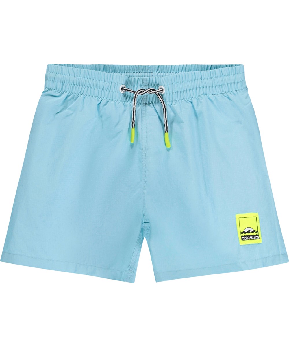 Niko Solid - Blue Light - Blaue, sportliche Badeshorts für Kinder aus recyceltem Nylon mit UV-Schutz 50+.