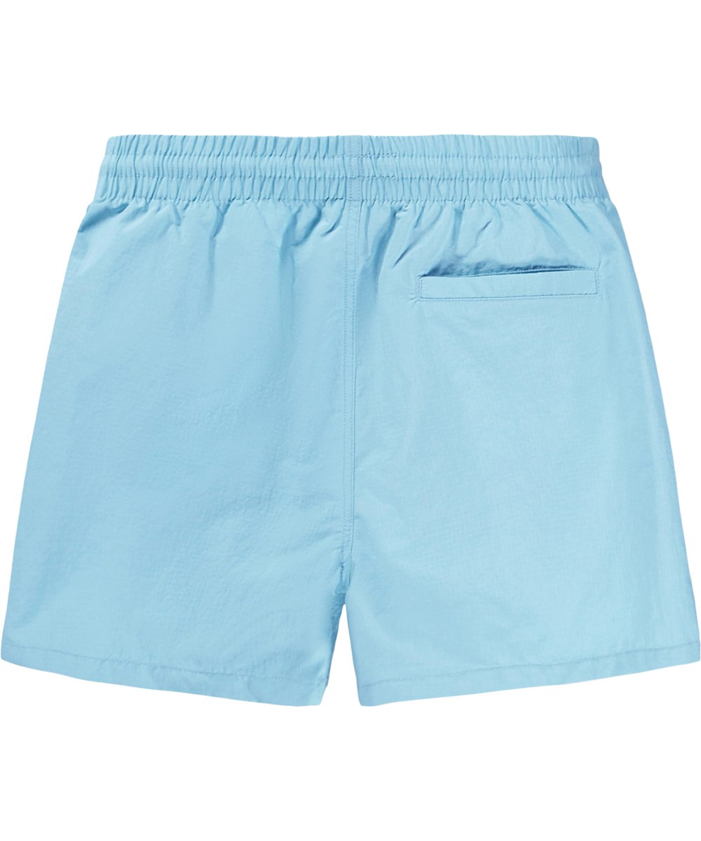 Niko Solid - Blue Light - Blaue, sportliche Badeshorts für Kinder aus recyceltem Nylon mit UV-Schutz 50+.