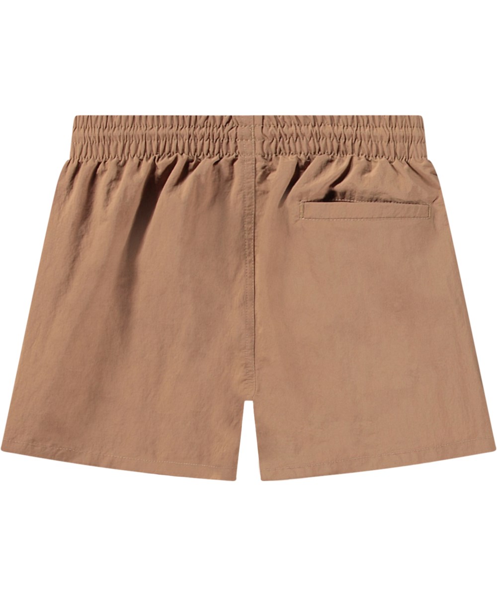Niko Solid - Sandalwood - Sportliche beige Badehosen für aktive Kinder aus recyceltem Nylon mit UV-Schutz 50+.