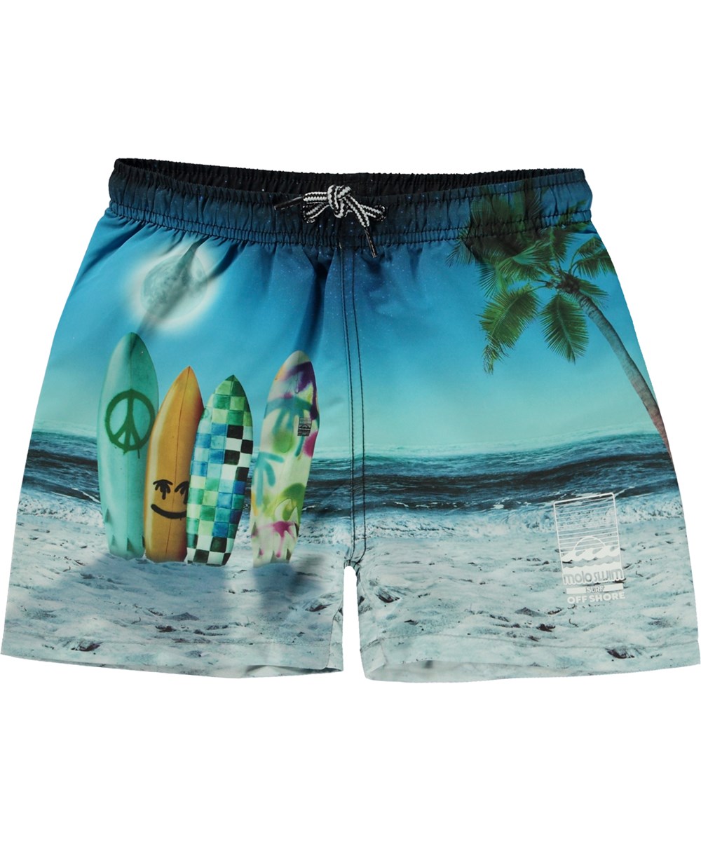 Niko - Sunset Surfer - Blaue Badeshorts mit kurzen Beinen und Placement-Surfbrett-Print