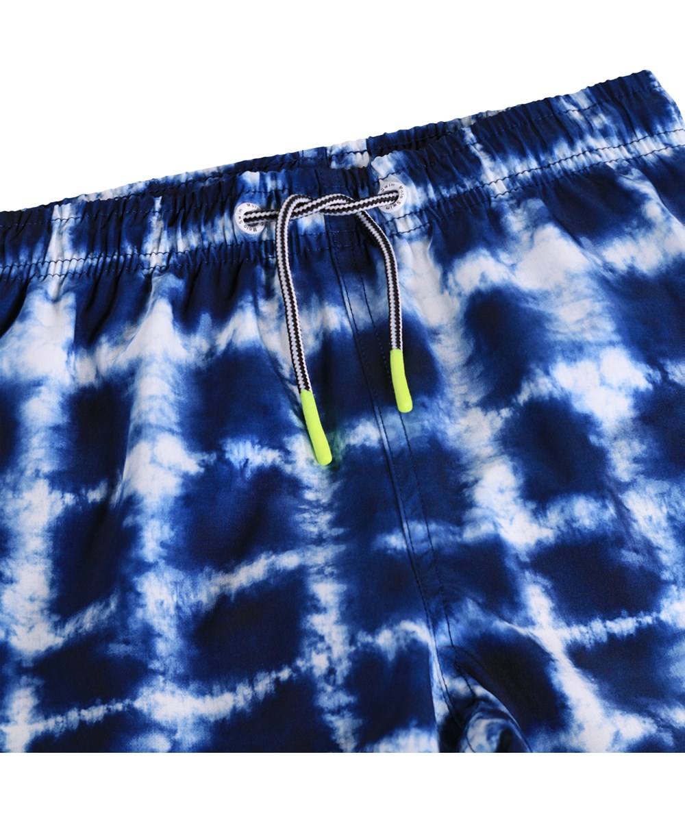 Niko - Tie Dye Check - Sportliche, blaue Badeshorts mit Batikmuster für aktive Kinder aus recyceltem Polyester mit UV-Schutz 50+.