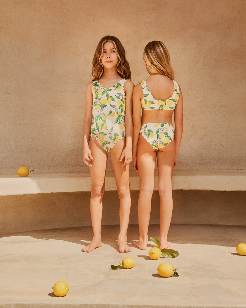 Noelle - Citrus - Gelber Badeanzug mit Wellenkanten und Zitrusdruck für Kinder aus recyceltem Polyester mit UV-Schutz 50+.